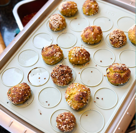 Kabeljauw balletjes op een bakplaat met sesamzaad